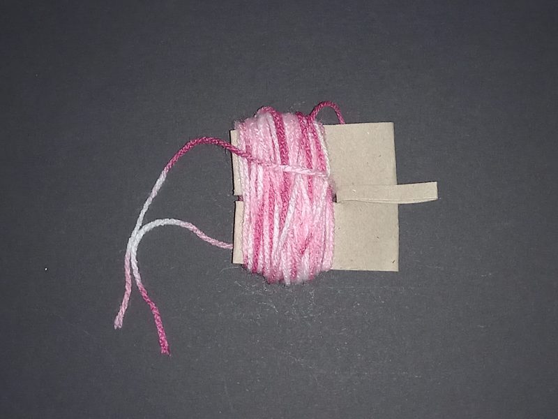 Spider Pompom Step 6: Thread the extra wool through the middle.