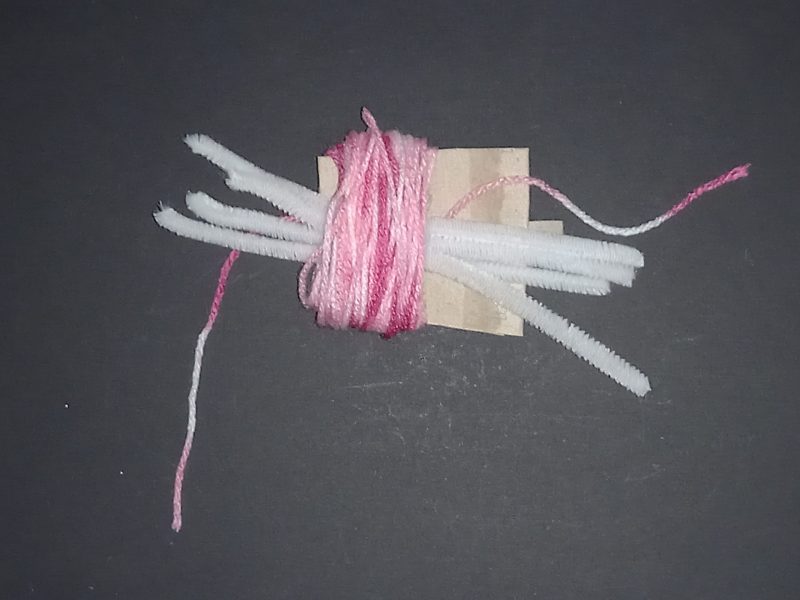 Spider Pompom Step 7: Put the pipecleaners through the middle of the wool.